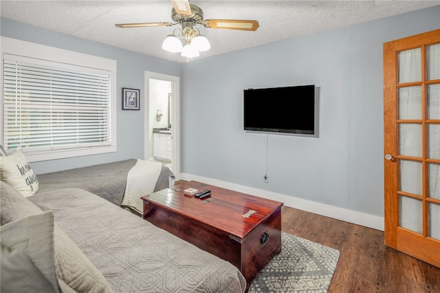 living room with ceiling fan, dark hardwood / wood-style floors, and a textured ceiling