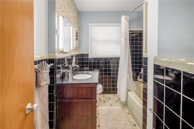 full bathroom with vanity, tile walls, shower / tub combo with curtain, and toilet