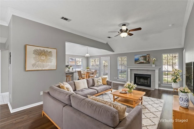 living room with a wealth of natural light, dark hardwood / wood-style flooring, and vaulted ceiling