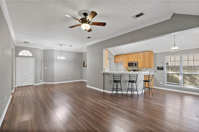 unfurnished living room featuring dark hardwood / wood-style floors, crown molding, and ceiling fan with notable chandelier