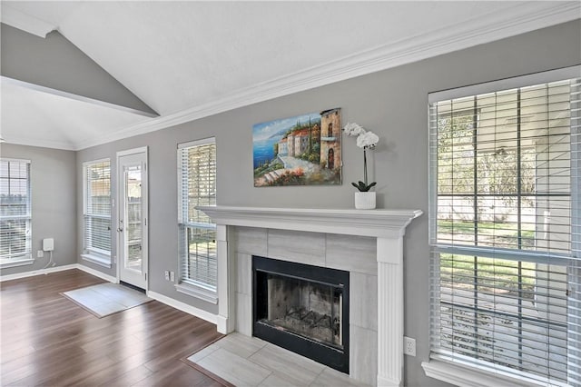 unfurnished living room with hardwood / wood-style floors, vaulted ceiling, plenty of natural light, and a tiled fireplace