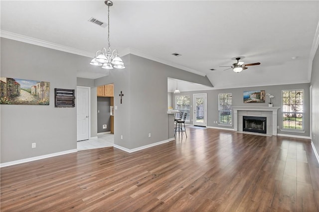 unfurnished living room with hardwood / wood-style floors, ceiling fan with notable chandelier, and ornamental molding