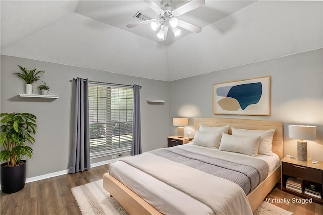 bedroom with dark hardwood / wood-style floors, vaulted ceiling, and ceiling fan