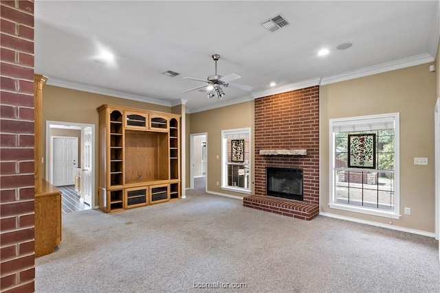 unfurnished living room with a brick fireplace, light carpet, ceiling fan, and ornamental molding