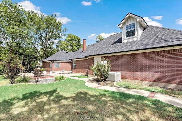 back of property featuring a lawn, cooling unit, and a patio area