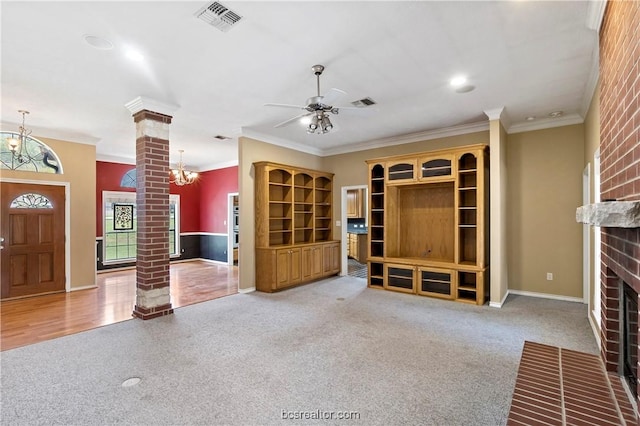 unfurnished living room with a brick fireplace, carpet floors, ornate columns, and ornamental molding