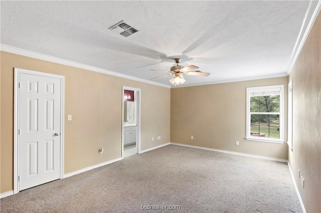 spare room featuring ornamental molding, a textured ceiling, and light carpet