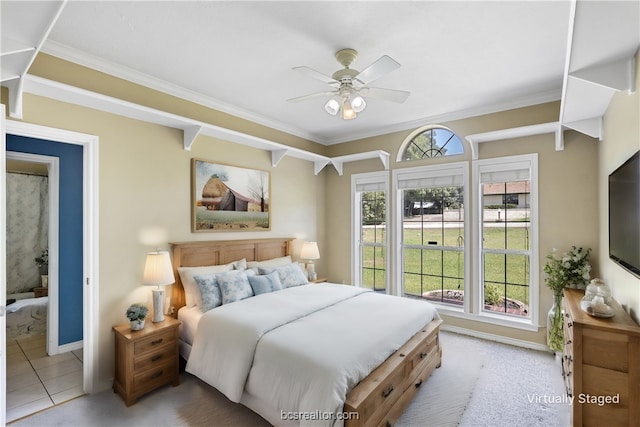 tiled bedroom featuring ceiling fan, crown molding, and ensuite bath