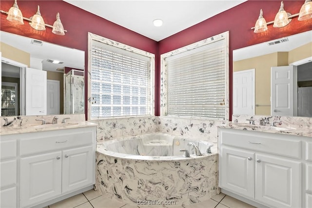 bathroom with tile patterned floors, vanity, and tiled bath