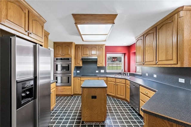 kitchen with stainless steel appliances, a kitchen island, and sink