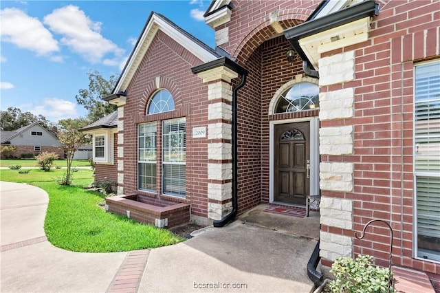 view of exterior entry featuring a yard