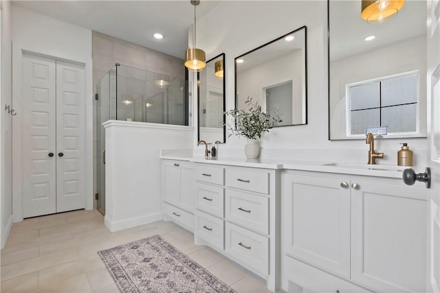 full bathroom with a sink, a closet, a stall shower, double vanity, and tile patterned flooring