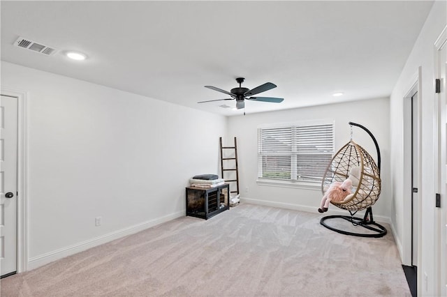 sitting room with baseboards, visible vents, a ceiling fan, and carpet