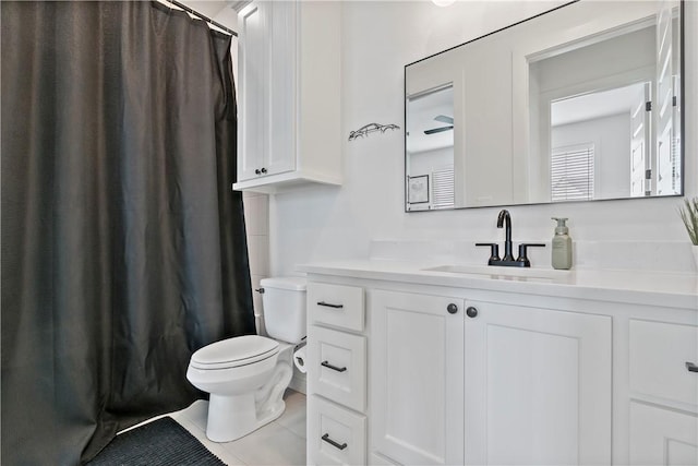 bathroom with toilet, tile patterned floors, curtained shower, and vanity