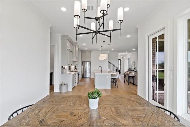 dining room with visible vents, ornamental molding, an inviting chandelier, and recessed lighting