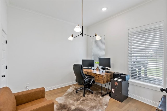 office space with baseboards, an inviting chandelier, light wood-style floors, and crown molding