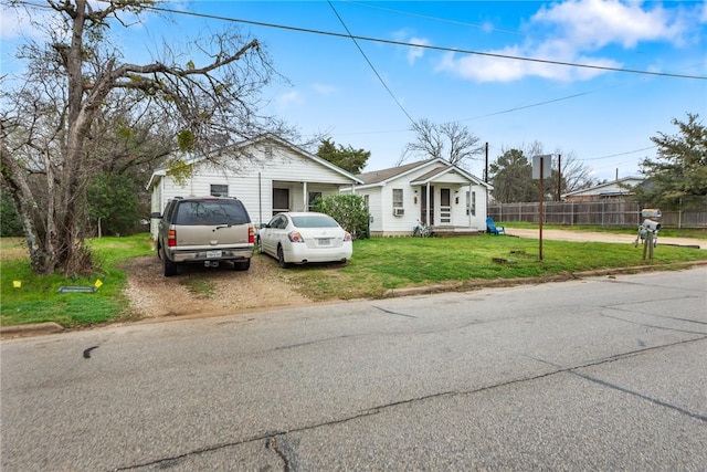 bungalow-style house with fence and a front lawn