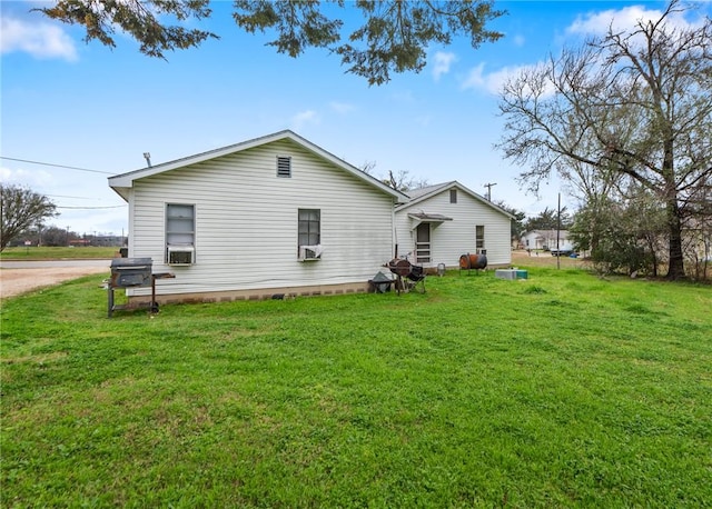 back of house featuring cooling unit and a lawn