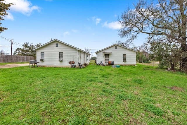 back of house featuring a lawn and fence