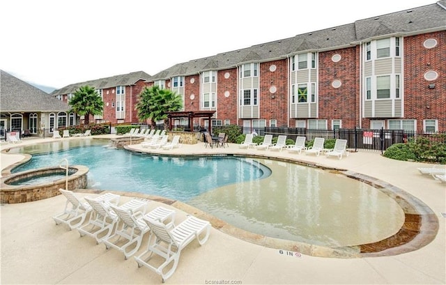 view of swimming pool with a pergola, pool water feature, a community hot tub, and a patio