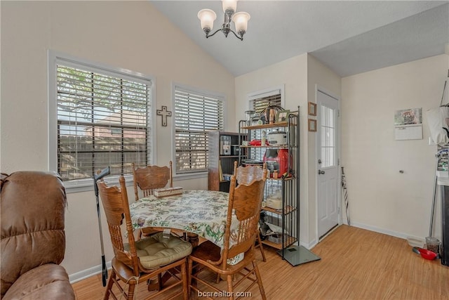 dining space featuring a chandelier, hardwood / wood-style floors, and vaulted ceiling