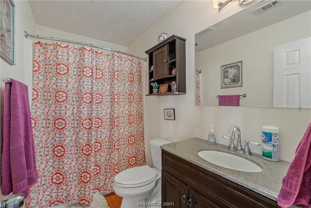 bathroom featuring vanity, toilet, and a textured ceiling