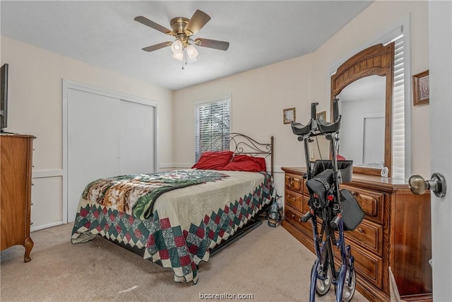 bedroom featuring ceiling fan, a closet, and light colored carpet