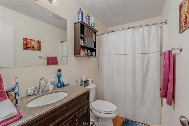 bathroom featuring toilet, vanity, a textured ceiling, and hardwood / wood-style flooring