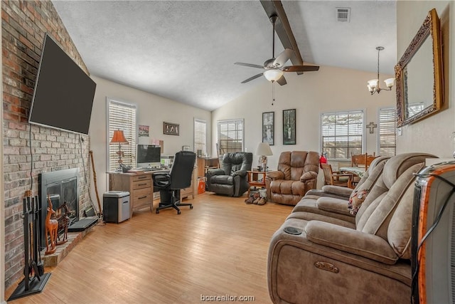 living room featuring ceiling fan with notable chandelier, light hardwood / wood-style flooring, vaulted ceiling with beams, a textured ceiling, and a fireplace