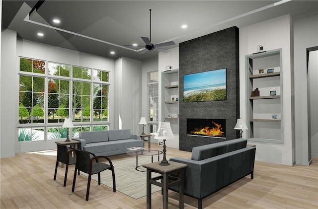 living room featuring a wealth of natural light, a fireplace, and light hardwood / wood-style flooring