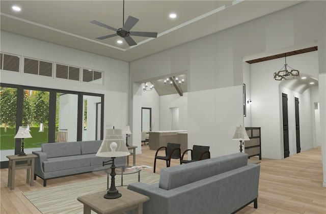 living room with a towering ceiling, ceiling fan with notable chandelier, and light hardwood / wood-style flooring