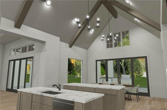 kitchen with pendant lighting, sink, beam ceiling, light stone counters, and an island with sink