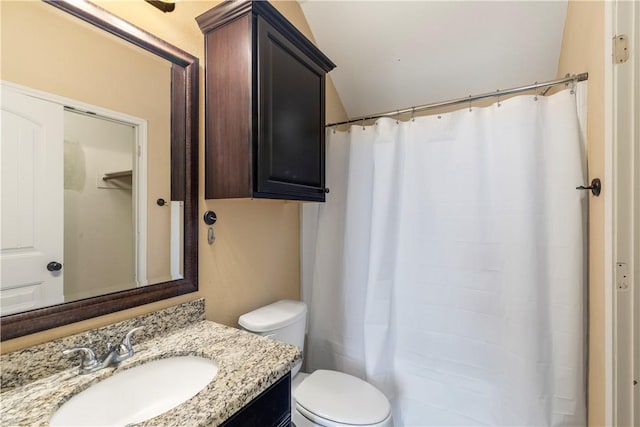 bathroom with vanity, curtained shower, and toilet