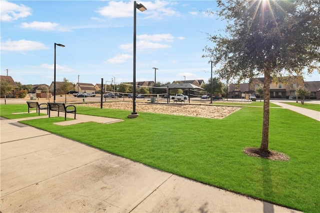 view of home's community featuring volleyball court and a lawn