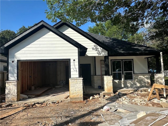 4111 Marsh St, Bryan, TX 77803 - view of front facade with a garage, roof with shingles, and stone siding