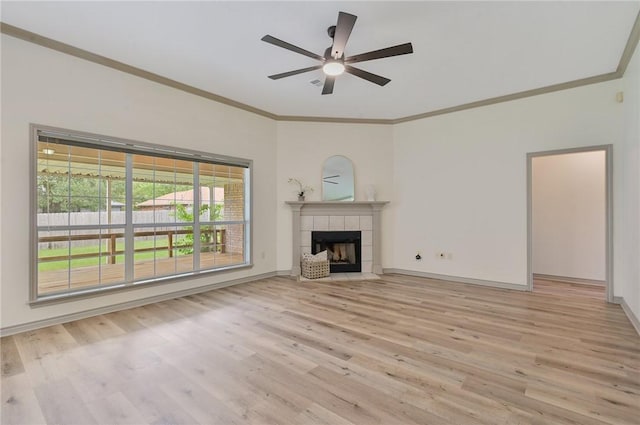 unfurnished living room with a fireplace, light hardwood / wood-style floors, ceiling fan, and crown molding