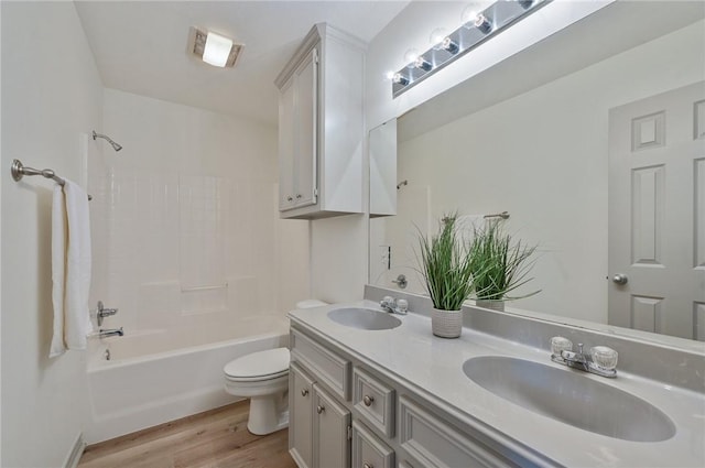 full bathroom with toilet, wood-type flooring, vanity, and bathing tub / shower combination