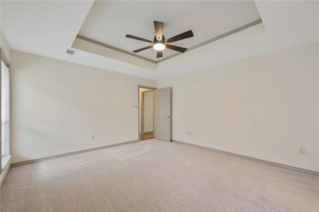 spare room with a raised ceiling and ceiling fan