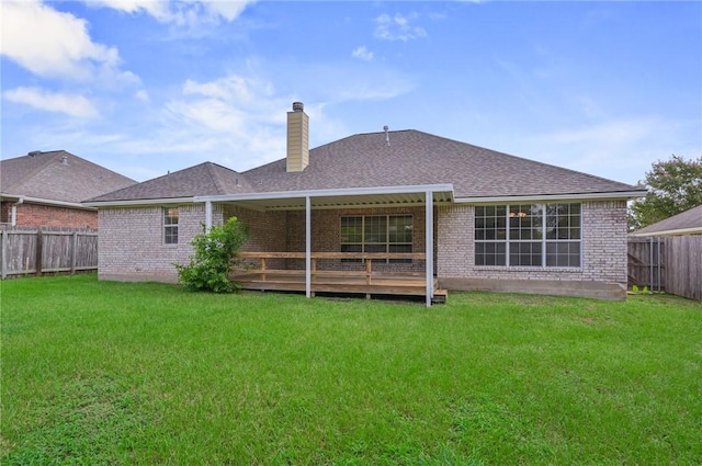 rear view of property with a yard and a wooden deck