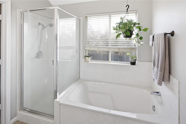 bathroom featuring shower with separate bathtub