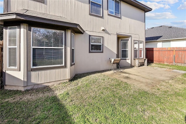 back of property featuring a patio area and a lawn