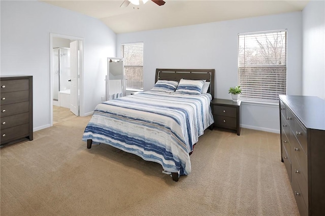 bedroom with lofted ceiling, light carpet, connected bathroom, and ceiling fan