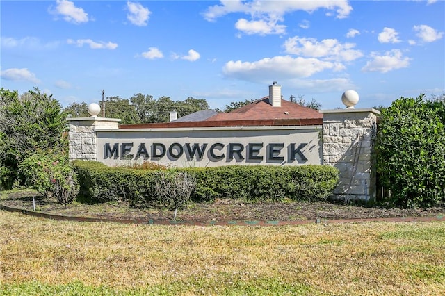 community / neighborhood sign with a lawn