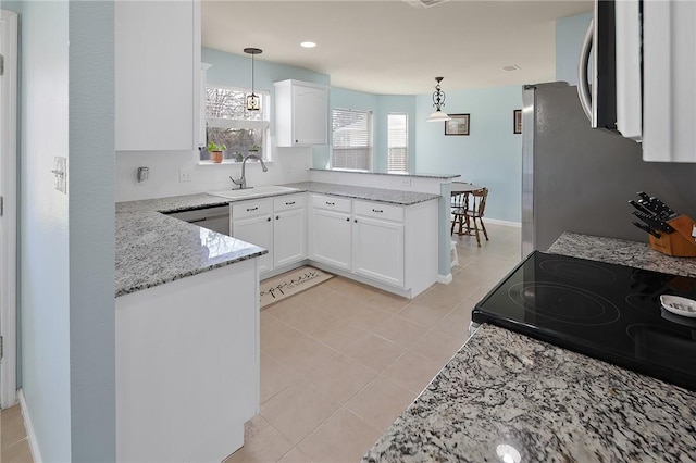 kitchen featuring decorative light fixtures, sink, white cabinets, and kitchen peninsula