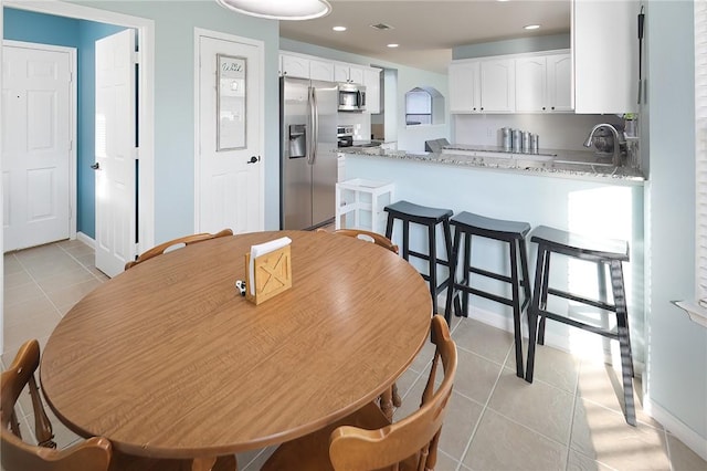 dining room featuring sink and light tile patterned floors