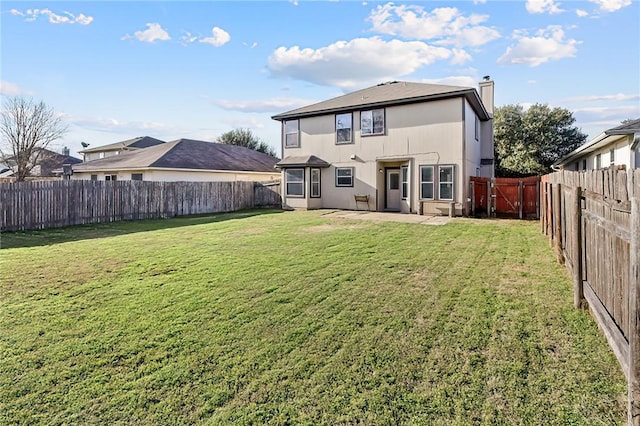 rear view of house with a patio and a lawn