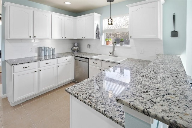 kitchen with sink, light stone counters, decorative light fixtures, stainless steel dishwasher, and white cabinets