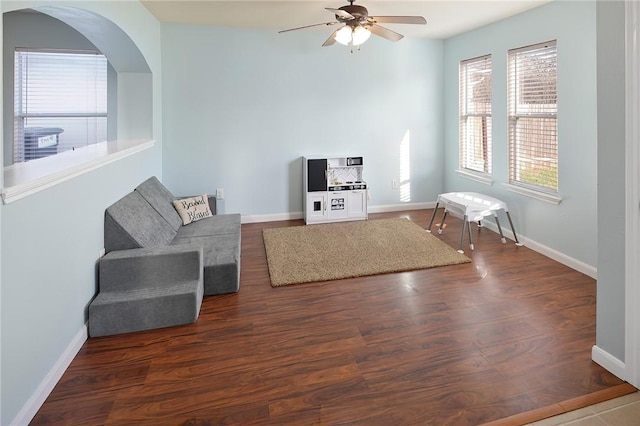 living room featuring ceiling fan and dark hardwood / wood-style flooring