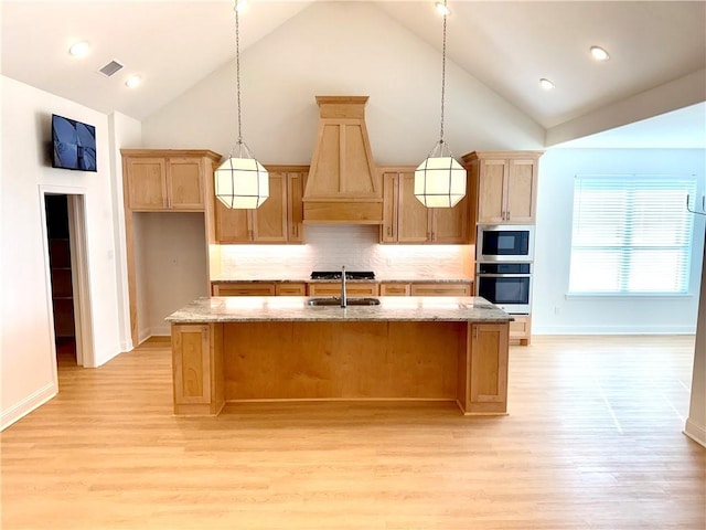 kitchen featuring sink, appliances with stainless steel finishes, a kitchen island with sink, decorative light fixtures, and custom exhaust hood