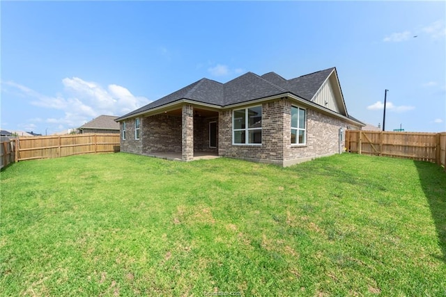 rear view of house featuring a yard and a patio